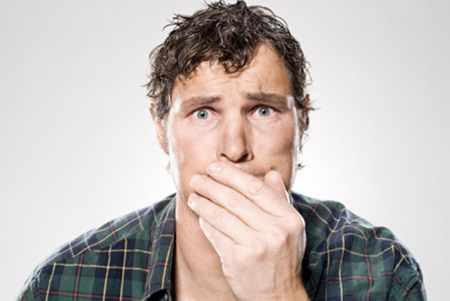 мужчина растеряно прикрывает рот рукой