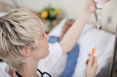 врач настраивает капельницу